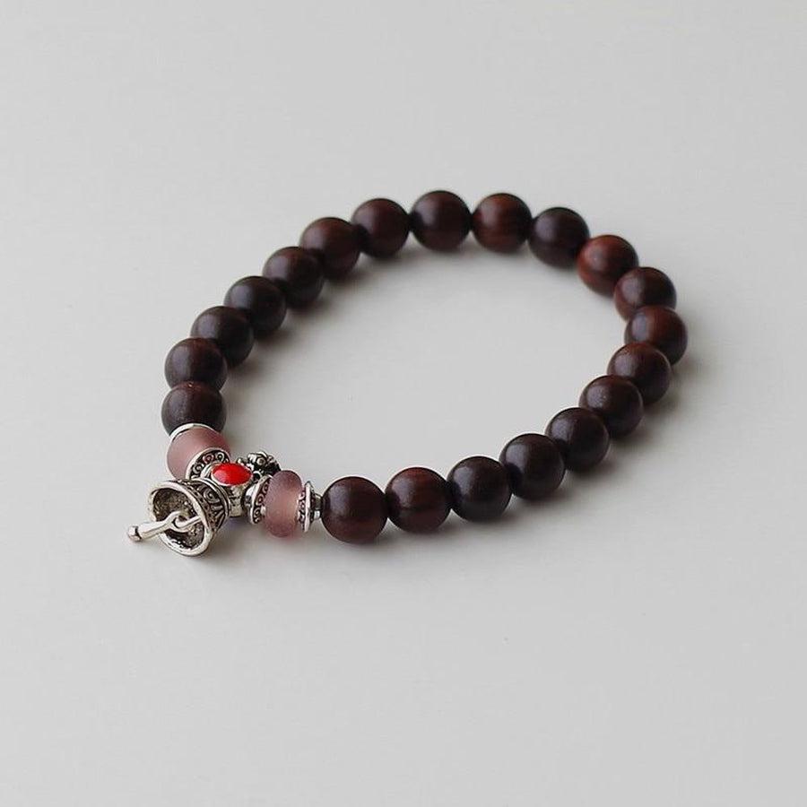 Bracelet de perles en bois avec clochette symbolique