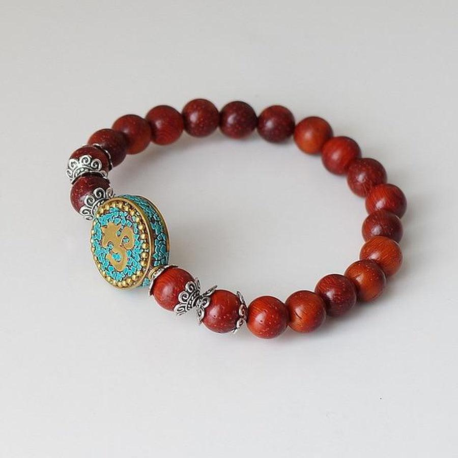 Gros plan sur les perles sculptées du bracelet Om