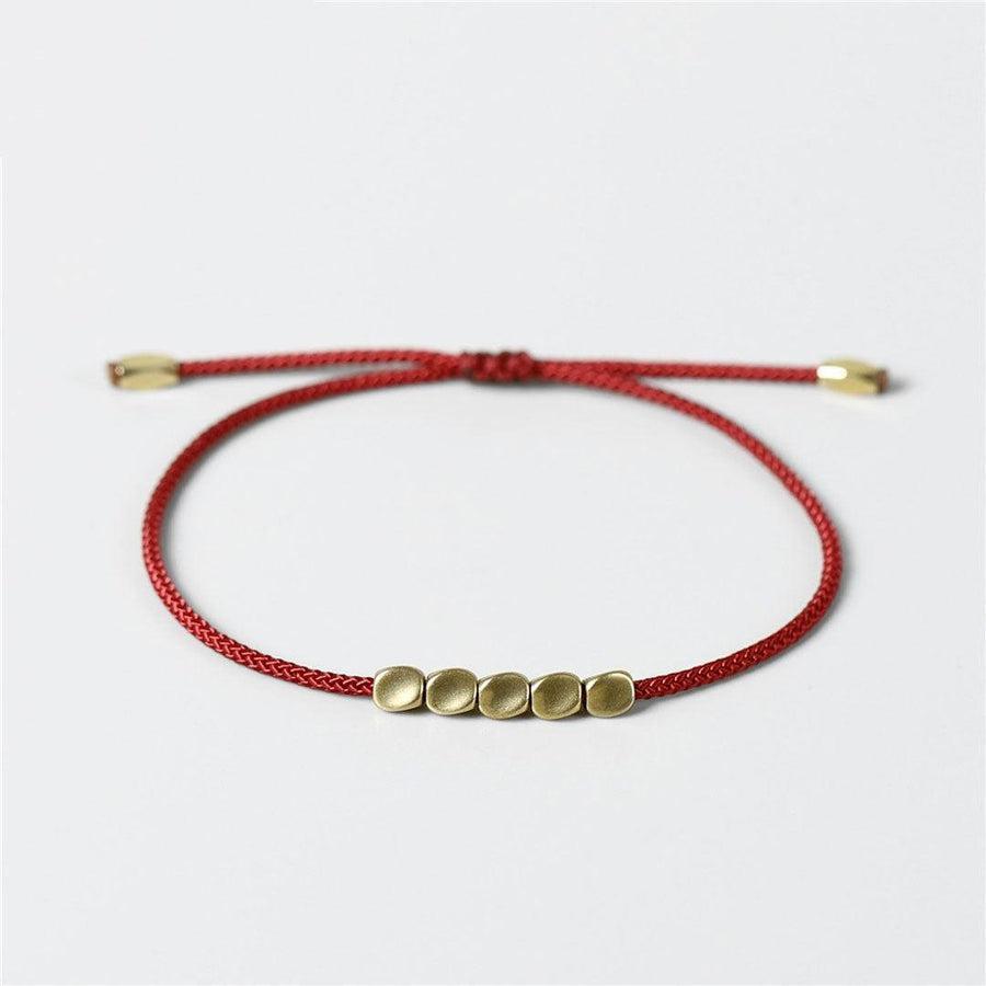 Bracelet tibétain multicolore posé sur une surface en bois