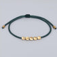Bracelet tibétain en cuivre avec perles, présenté enroulé