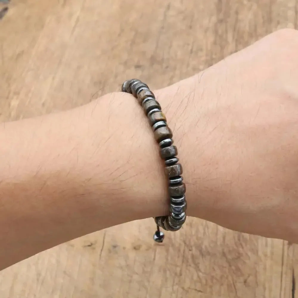 Bracelet en Bronzite et Hématite posé sur une surface en bois