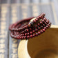 Gros plan sur les perles rouges du bracelet de méditation