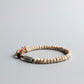 Vue latérale du bracelet montrant les graines et la perle