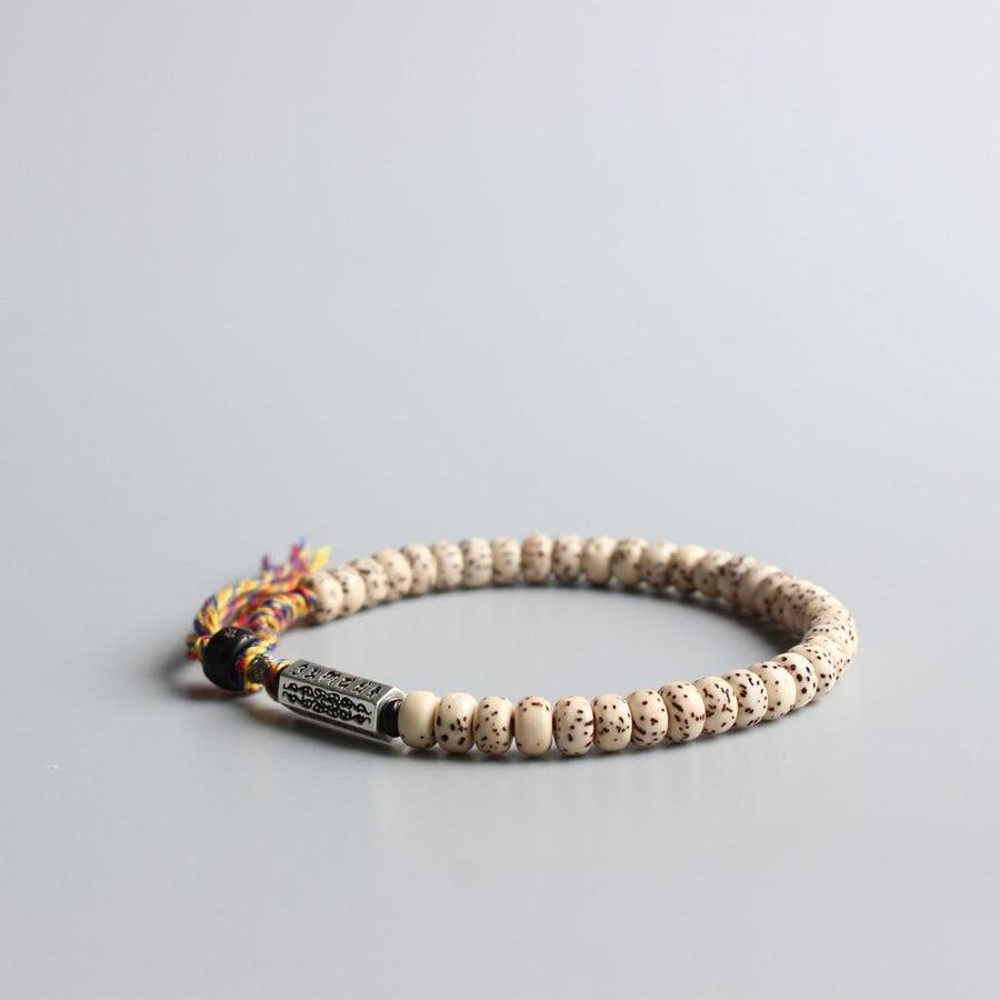 Vue latérale du bracelet montrant les graines et la perle