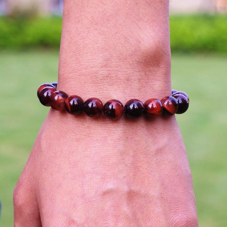 Bracelet en Œil de tigre rouge posé sur une surface