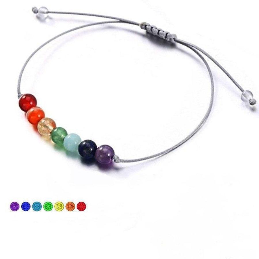 Bracelet 7 Chakras posé sur une surface en bois