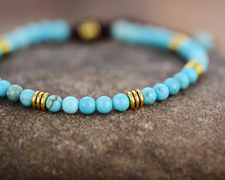 Gros plan sur perles turquoise et dorées du bracelet