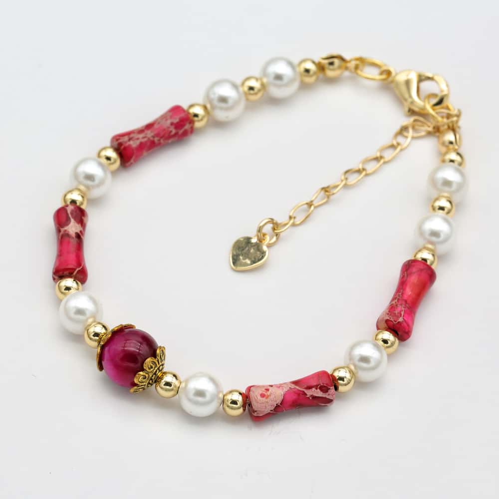Bracelet avec perles roses et dorées sur fond blanc