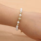 Bracelet perles nacrées avec strass doré en gros plan