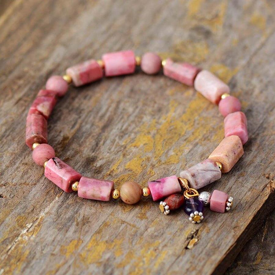 Gros plan sur perles de rhodonite et dorées du bracelet