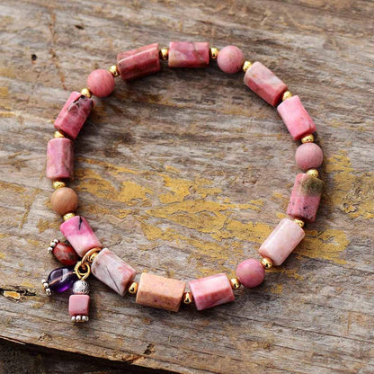 Zoom sur les perles taillées en rhodonite et dorées