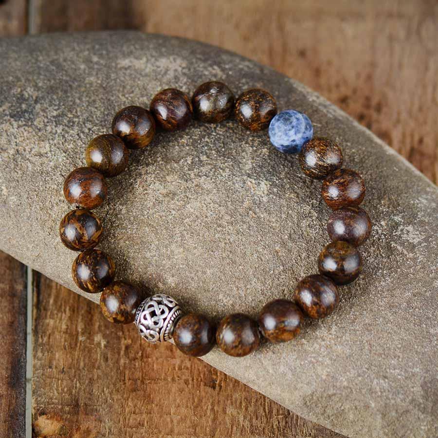 Bracelet en bronzite posé sur une surface claire
