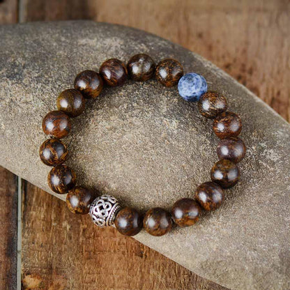 Bracelet en bronzite posé sur une surface claire