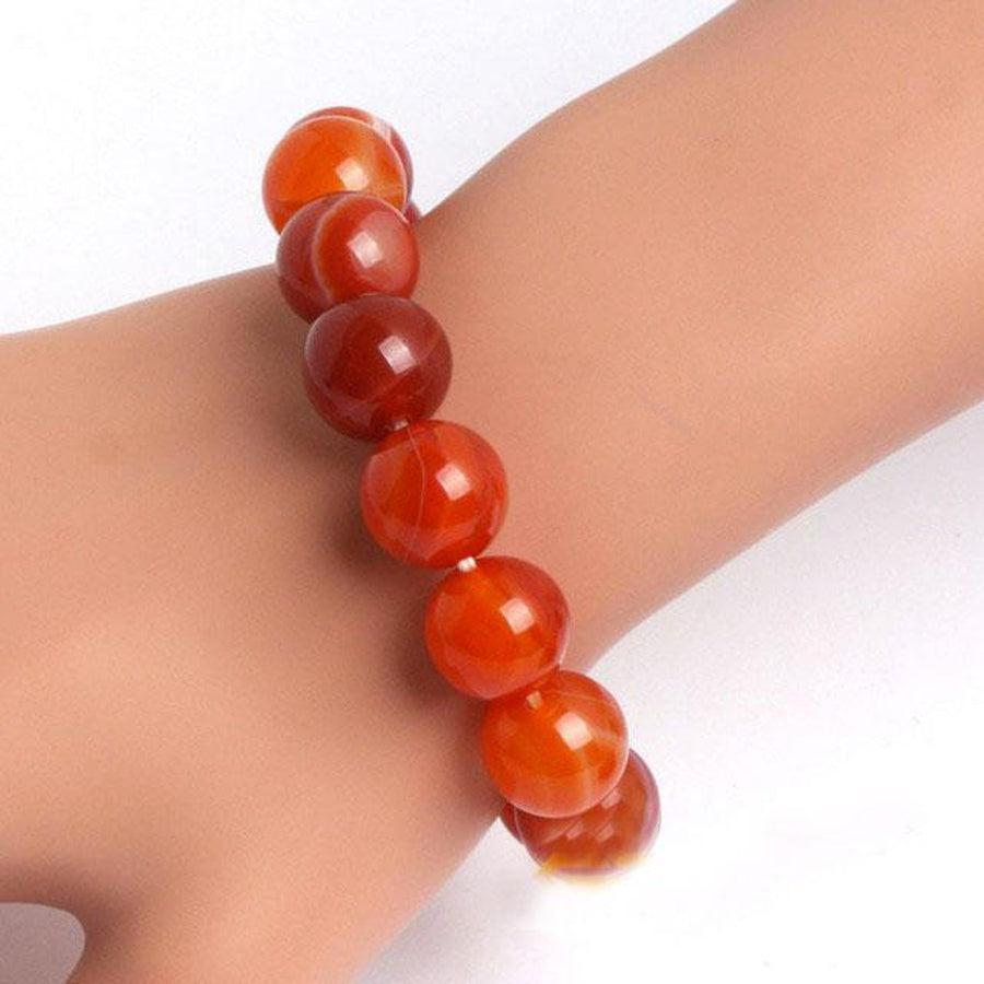 Bracelet en Cornaline rouge posé sur une surface en bois