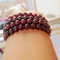 Bracelet en grenat avec perles polies sur fond blanc