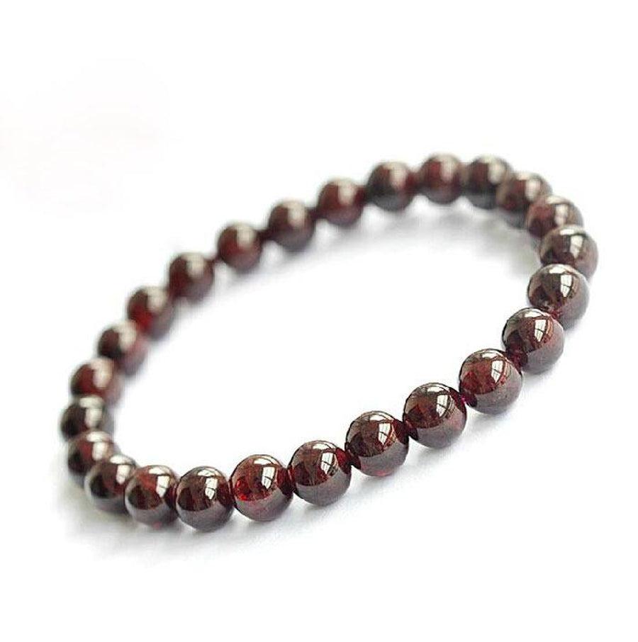 Gros plan sur les perles rouges du bracelet grenat