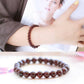 Bracelet grenat élégant posé sur une surface en bois