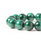 Gros plan sur les perles lisses du bracelet en malachite
