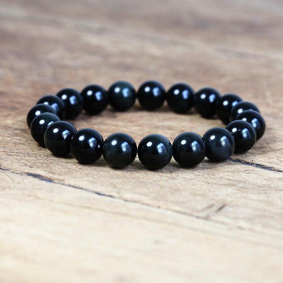 Gros plan sur les perles d'obsidienne noire, texture brillante