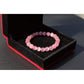 Bracelet en opale rose posé sur une surface en bois