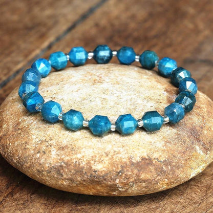 Détail des perles bleues du bracelet en apatite sur fond neutre