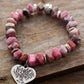 Gros plan sur perles roses et charme arbre de vie