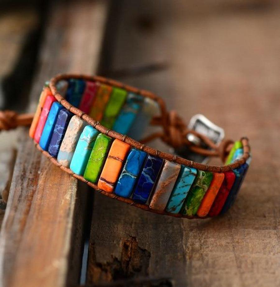 Bracelet en jaspe et cuir, posé sur une surface texturée