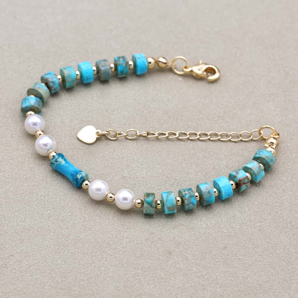 Bracelet turquoise avec perles blanches et dorées en gros plan