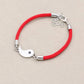 Deux bracelets tressés, noir et rouge, posés sur une surface