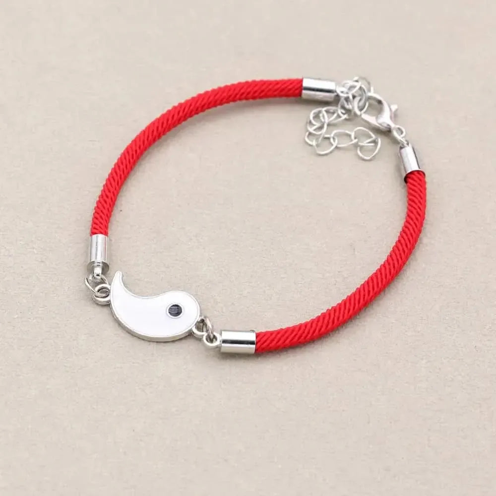 Deux bracelets tressés, noir et rouge, posés sur une surface