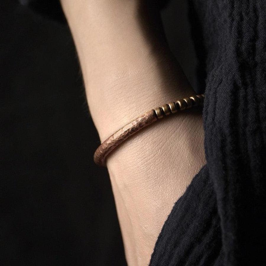 Gros plan sur perles de cuivre martelées du bracelet
