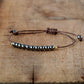 Bracelet en hématite avec perles dorées sur fond blanc