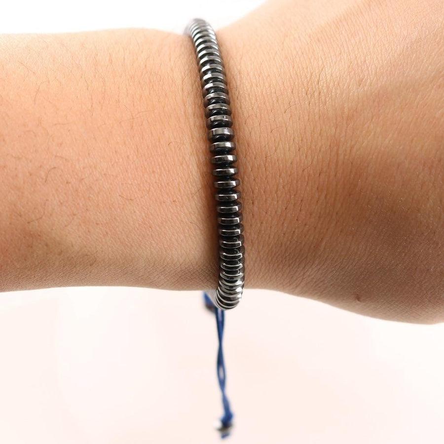 Bracelet en hématite posé sur une surface en bois