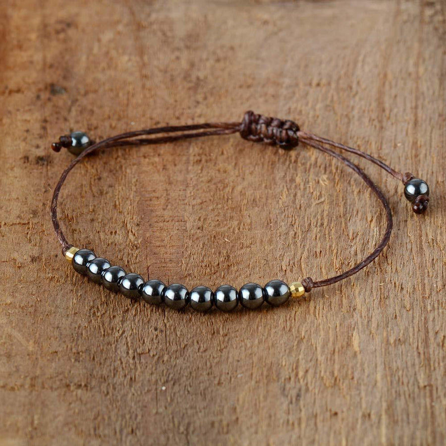 Bracelet en hématite posé sur une surface en bois clair