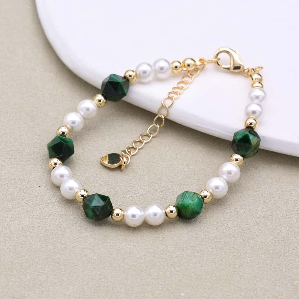 Détail des perles facettées vertes et blanches du bracelet