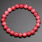 Gros plan sur les perles de rhodonite, mettant en valeur leur texture