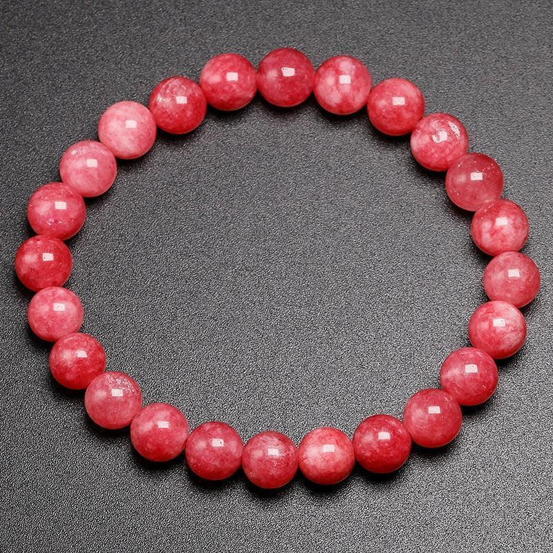 Gros plan sur les perles de rhodonite, mettant en valeur leur texture
