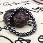 Bracelet en hématite avec perles brillantes sur fond blanc