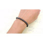 Bracelet magnétique en hématite posé sur une surface en bois