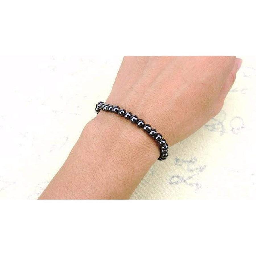 Bracelet magnétique en hématite posé sur une surface en bois