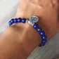 Gros plan sur perles bleues et pendentif Om