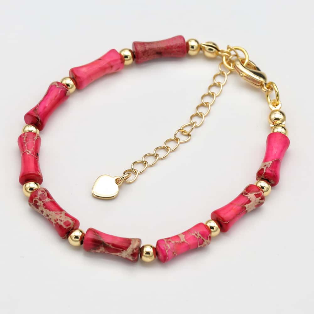 Bracelet avec perles roses et or sur fond blanc