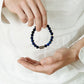 Gros plan sur les reflets bleus des perles du bracelet