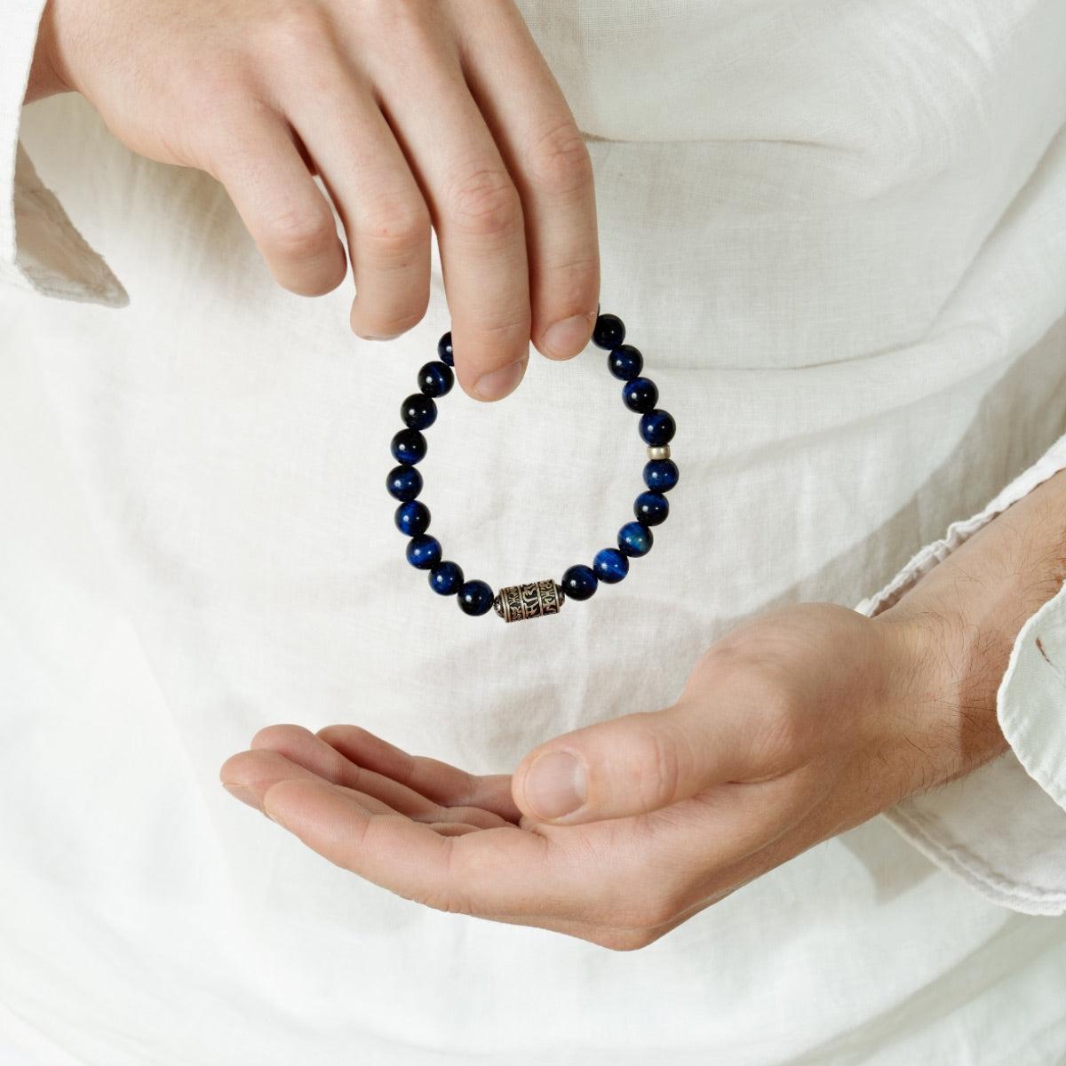Gros plan sur les reflets bleus des perles du bracelet