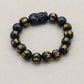 Vue rapprochée du Pixiu en obsidienne sur le bracelet
