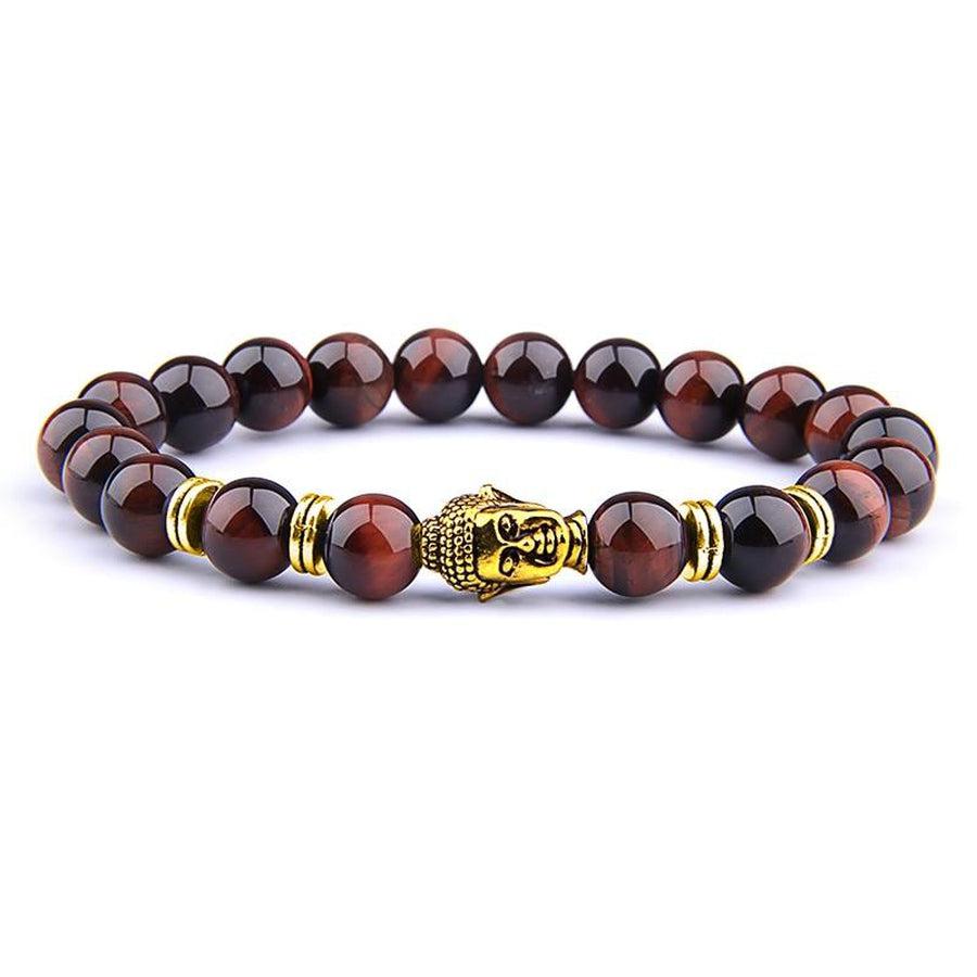 Gros plan sur les perles rouges et Bouddha du bracelet
