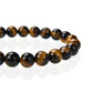 Gros plan sur les perles lisses du bracelet Œil de tigre