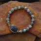 Bracelet artisanal en labradorite posé sur une surface claire