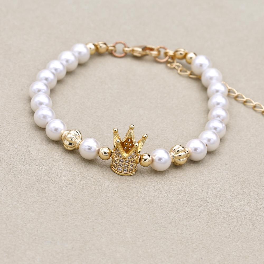 Bracelet avec perles blanches et dorées en gros plan