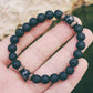 Gros plan sur les perles de lave et bois du bracelet